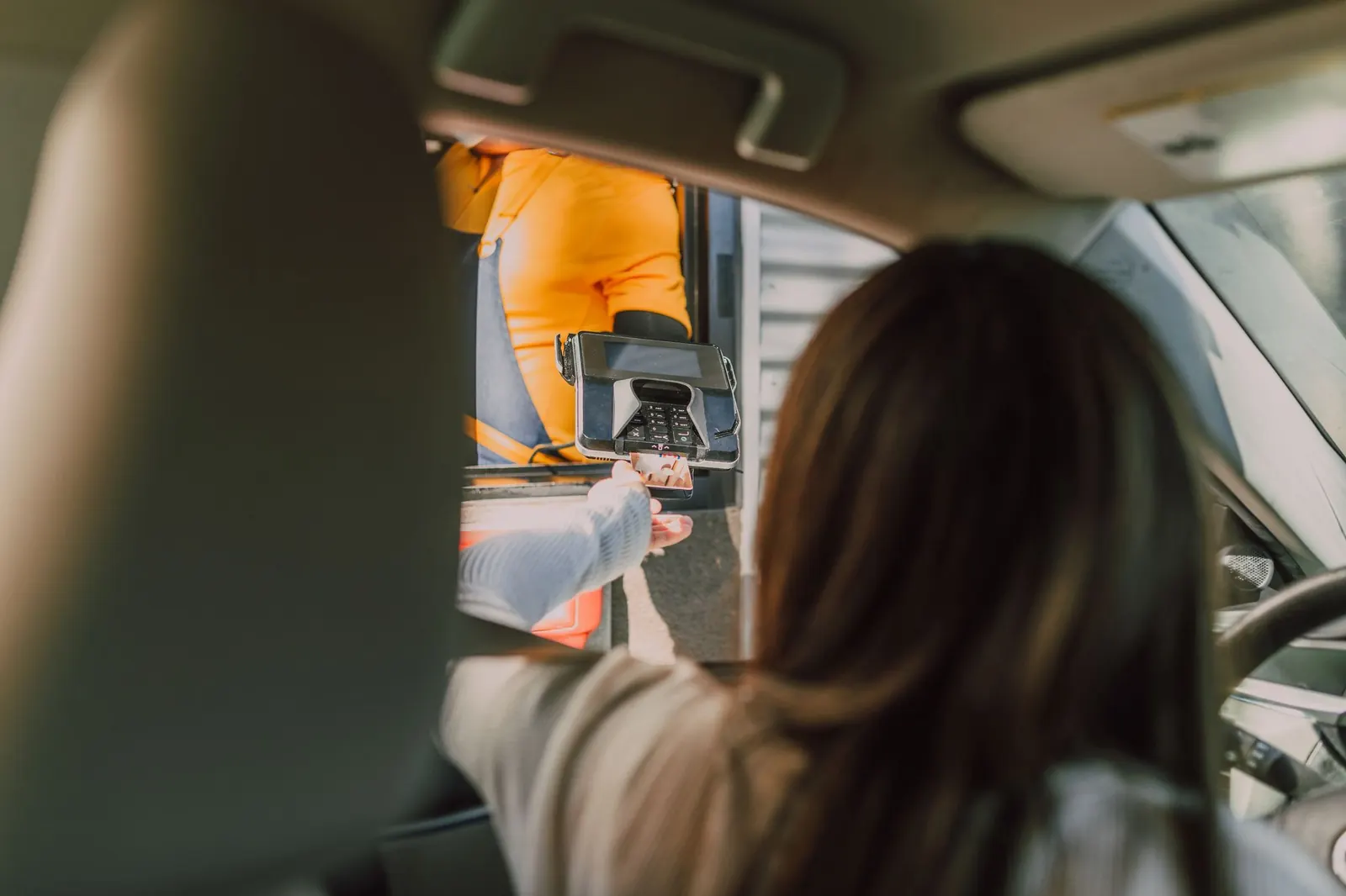 Customer paying at a drive-thru window